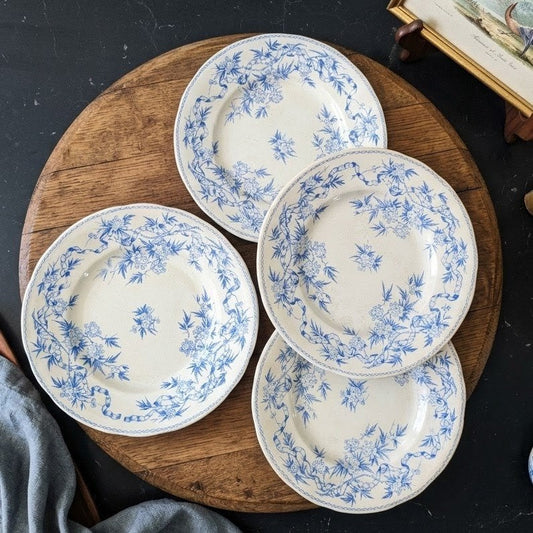 Lot of four 19th-century French antique Terre de Fer plates by U&C Sarreguemines. The "Epine" (Thorn) pattern features a detailed transferware design of blue thorny roses, bamboo stalks, and small blossoms on a cream earthenware base