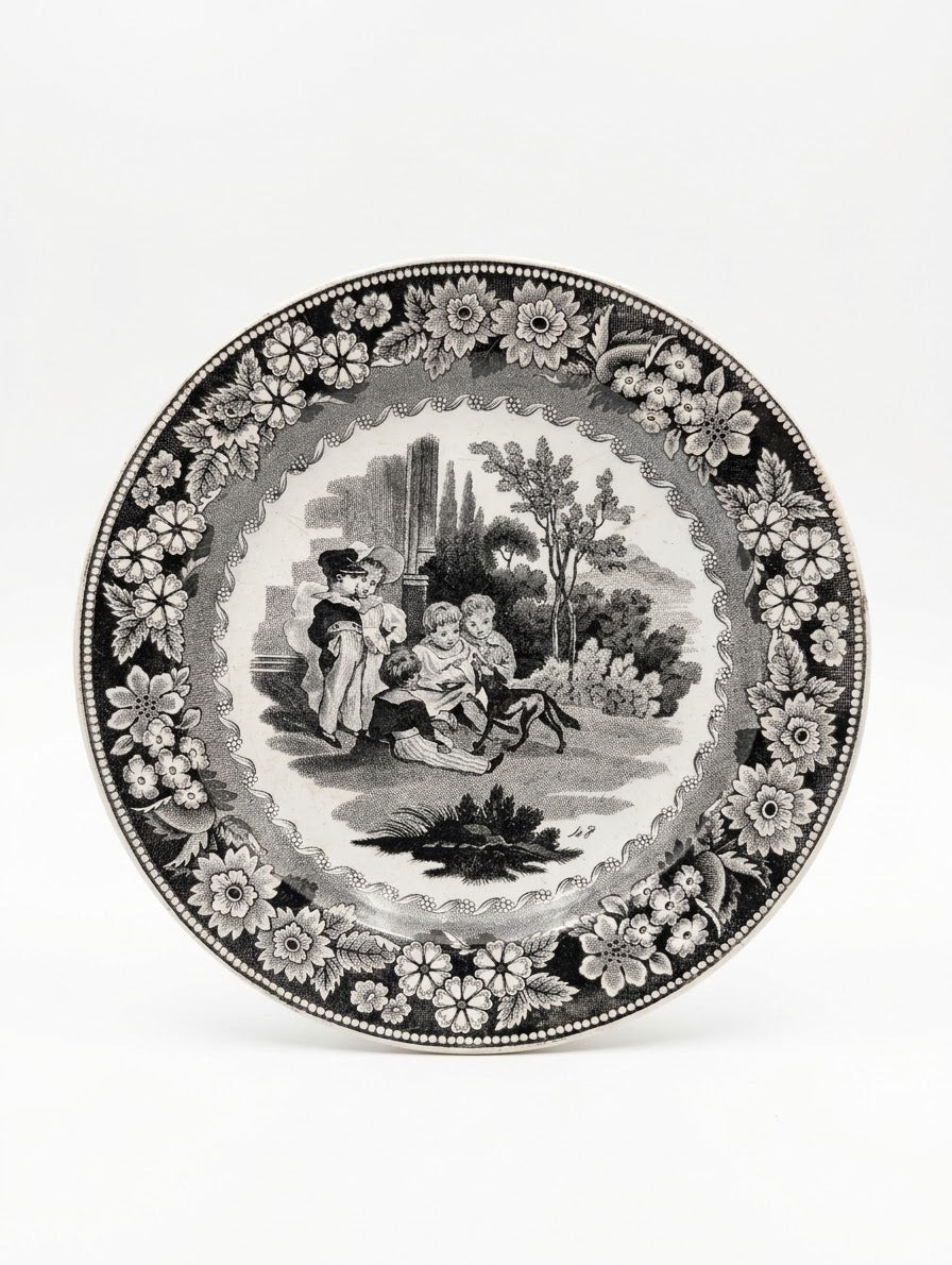 Assiette ancienne en faïence de Creil (estampillée Creil en creux). Décor noir imprimé scène d'enfants et frise florale. Pièce de collection d'époque unique ! 