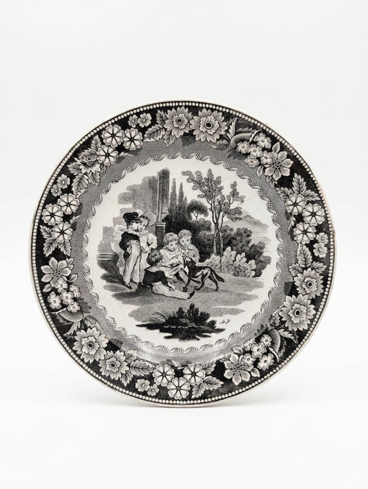 Assiette ancienne en faïence de Creil (estampillée Creil en creux). Décor noir imprimé scène d'enfants et frise florale. Pièce de collection d'époque unique ! 