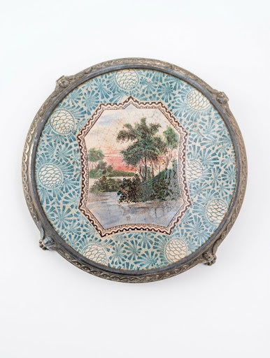 Dessous de plat ancien en Terre de Fer polychrome, médaillon paysage romantique et monture en métal argenté
